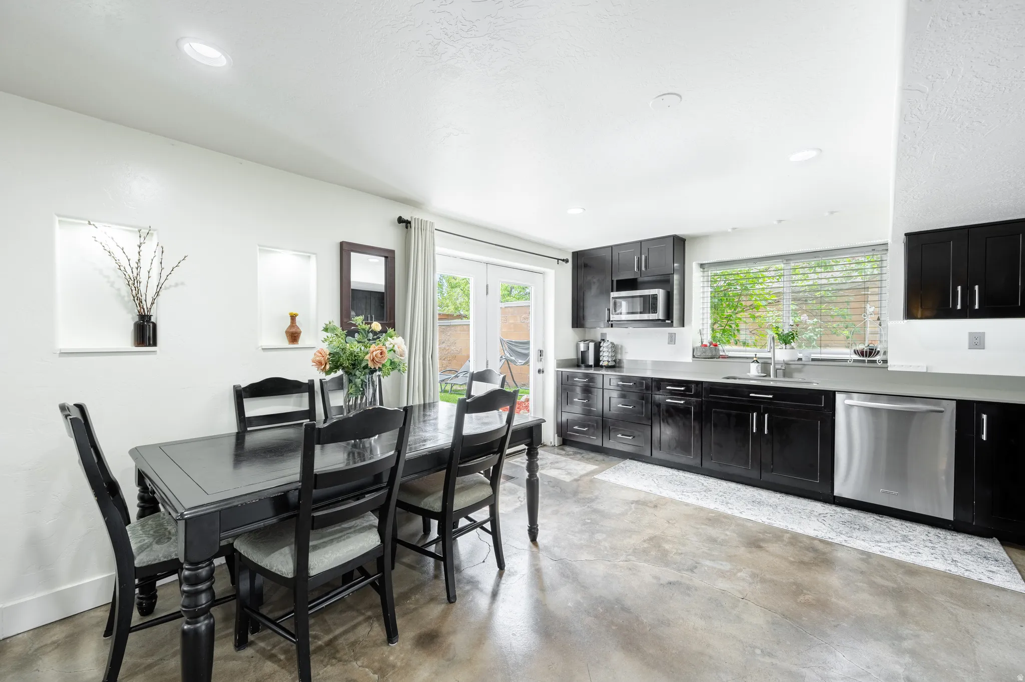 Dining space featuring concrete flooring, french doors, and recessed lighting