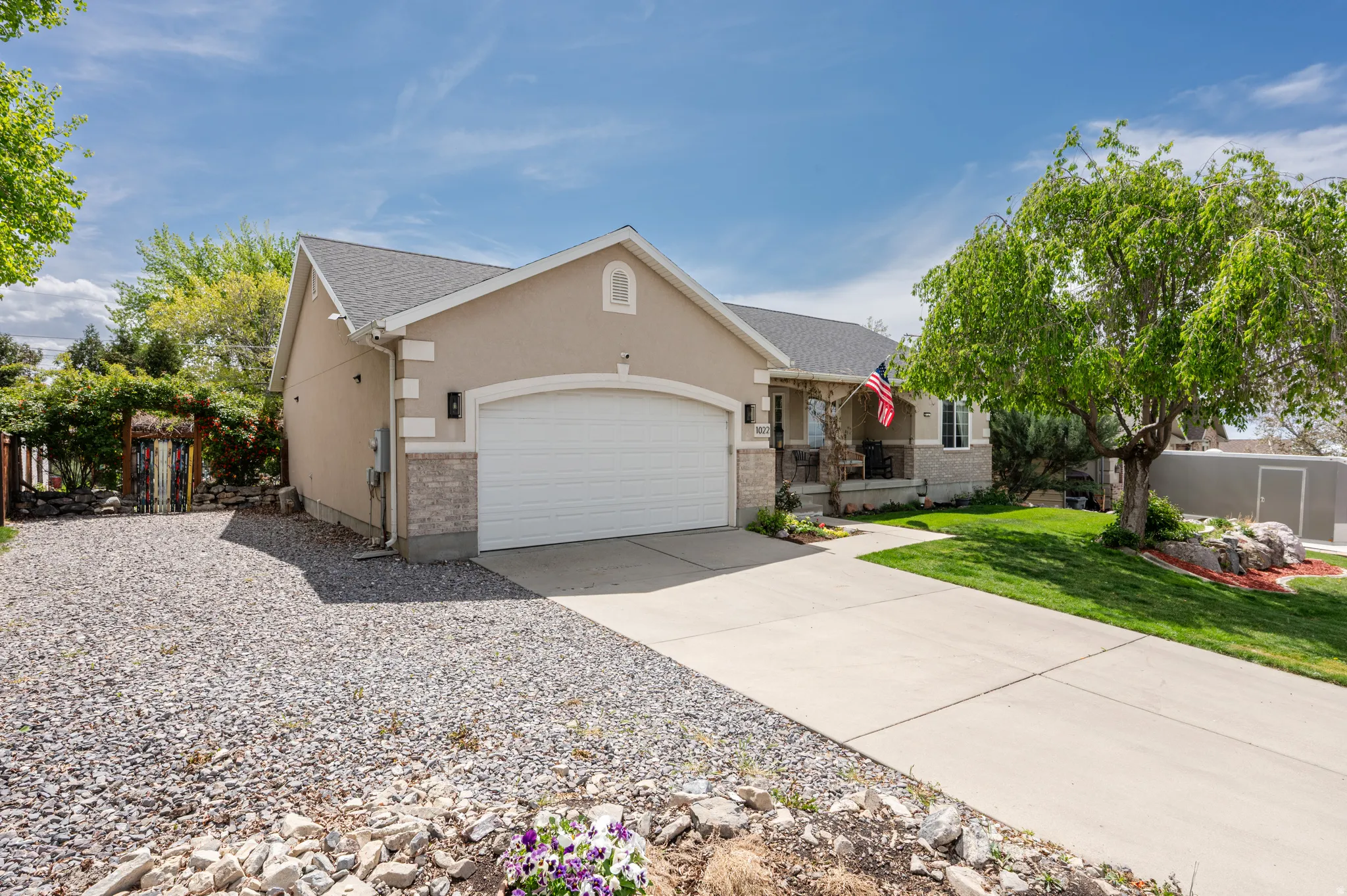 View of front of property featuring driveway, an attached garage, and stucco siding