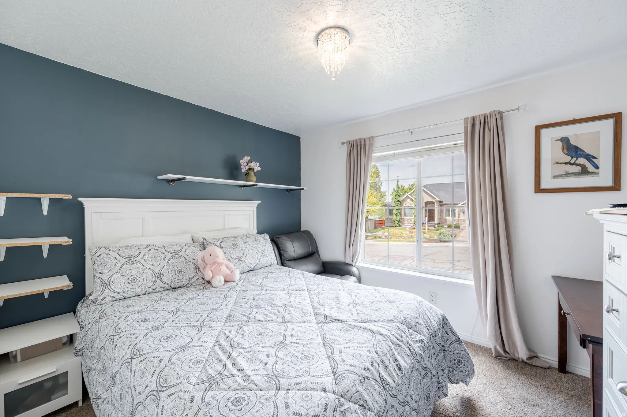 Bedroom featuring light colored carpet and a textured ceiling