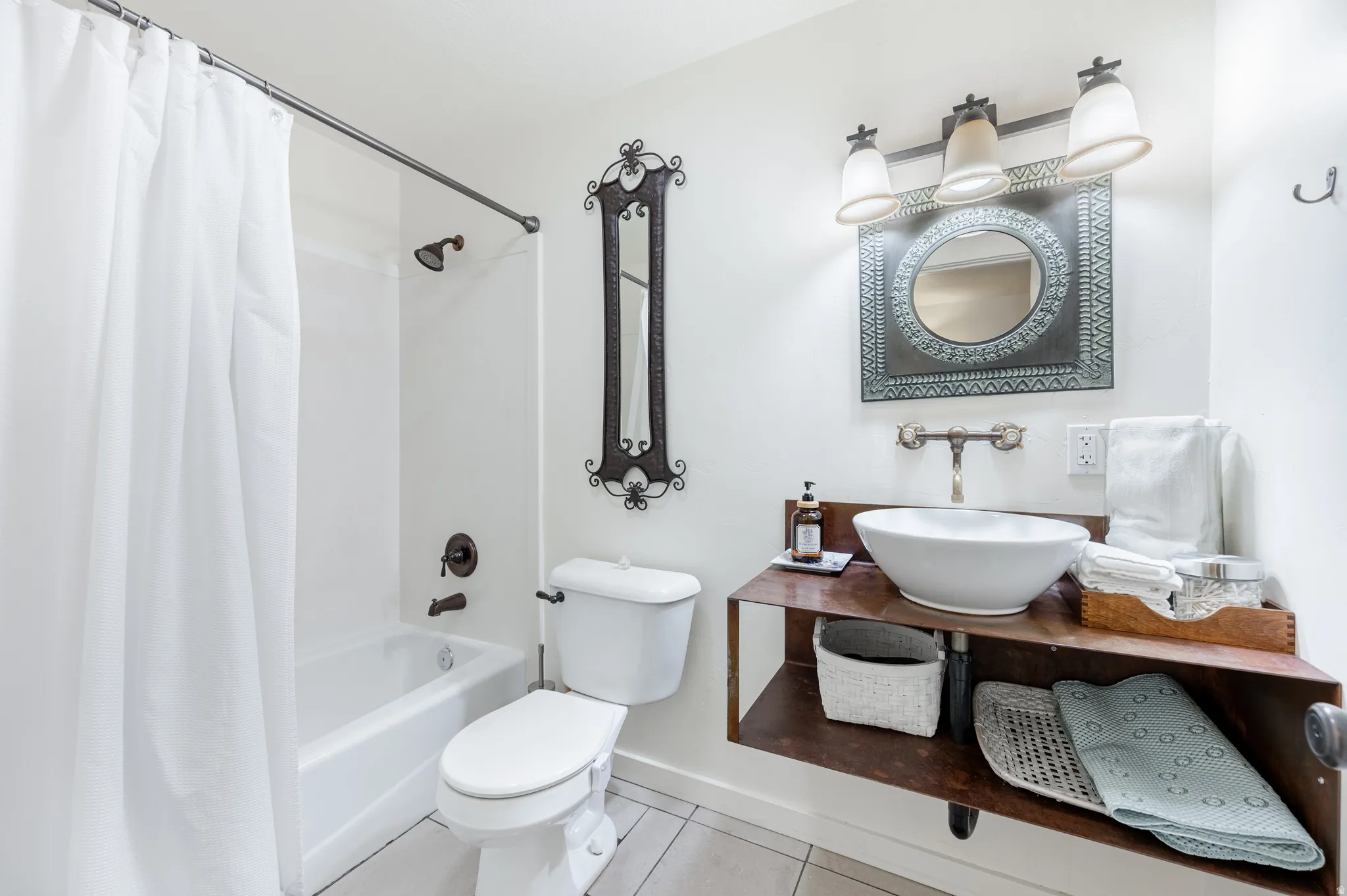 Full bath with vanity, light tile patterned floors, and shower / tub combo