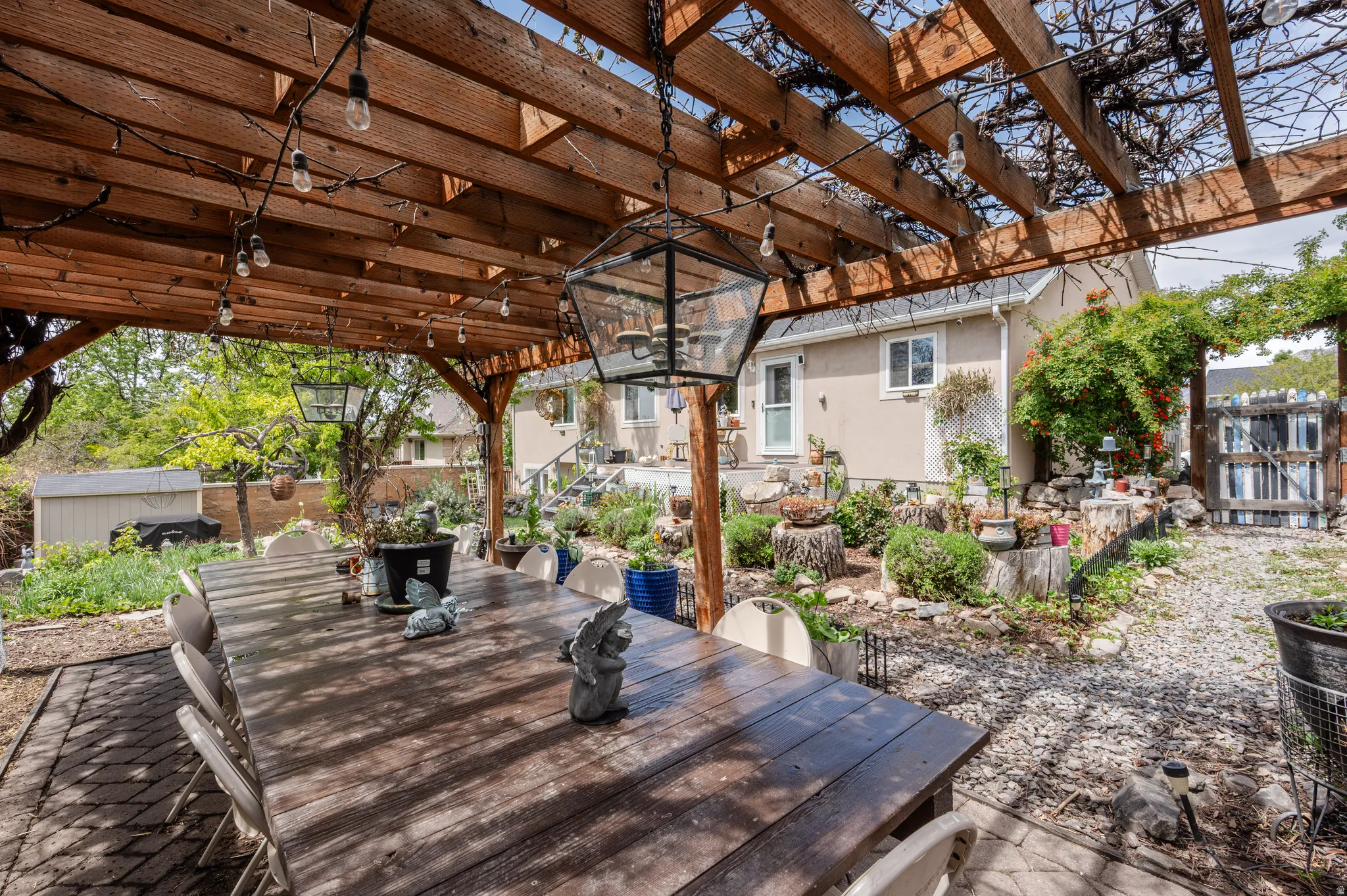 Wooden terrace with outdoor dining space, a pergola, an outbuilding, and a patio area
