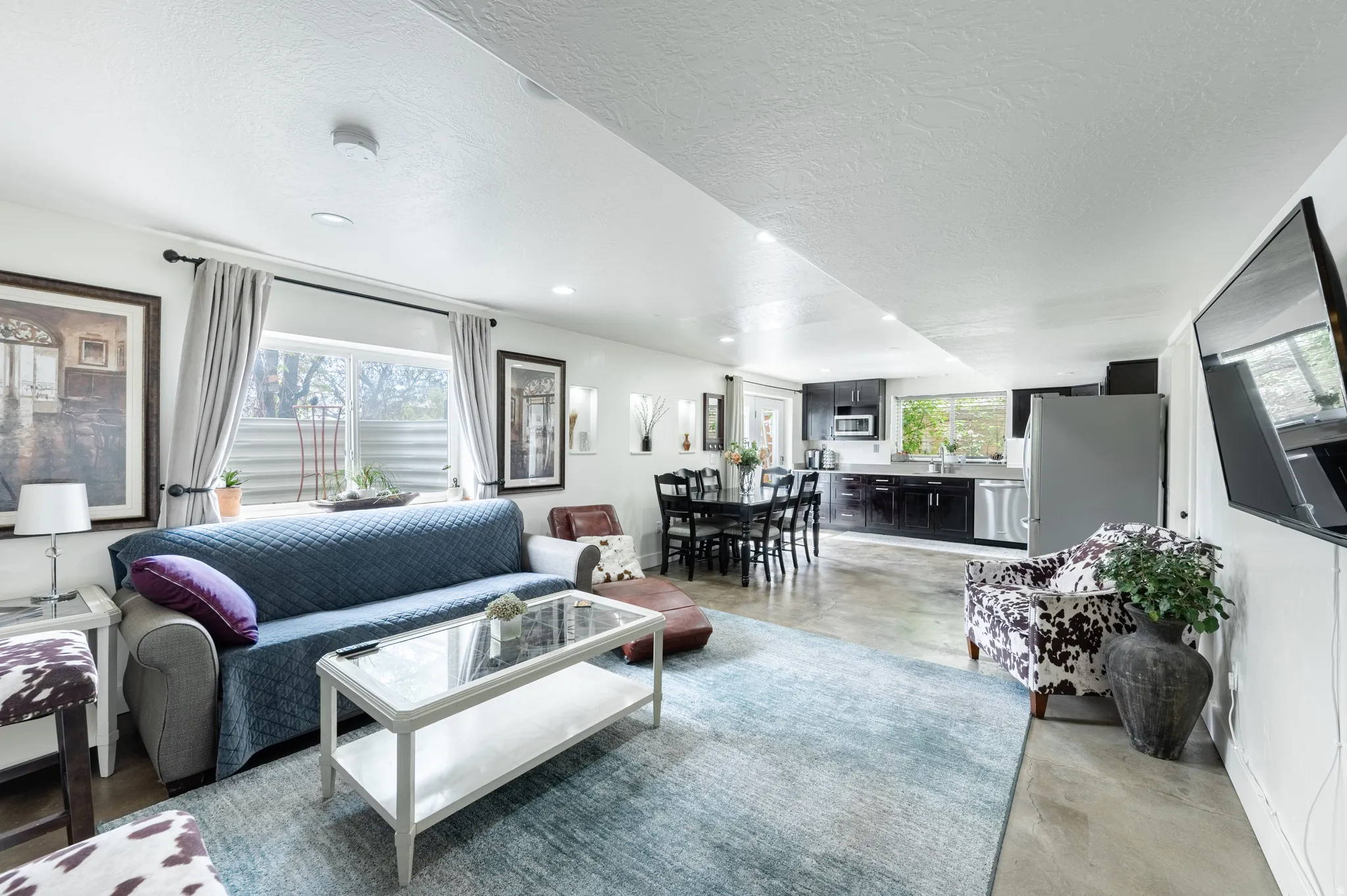 Living area with concrete floors, healthy amount of natural light, a textured ceiling, and recessed lighting