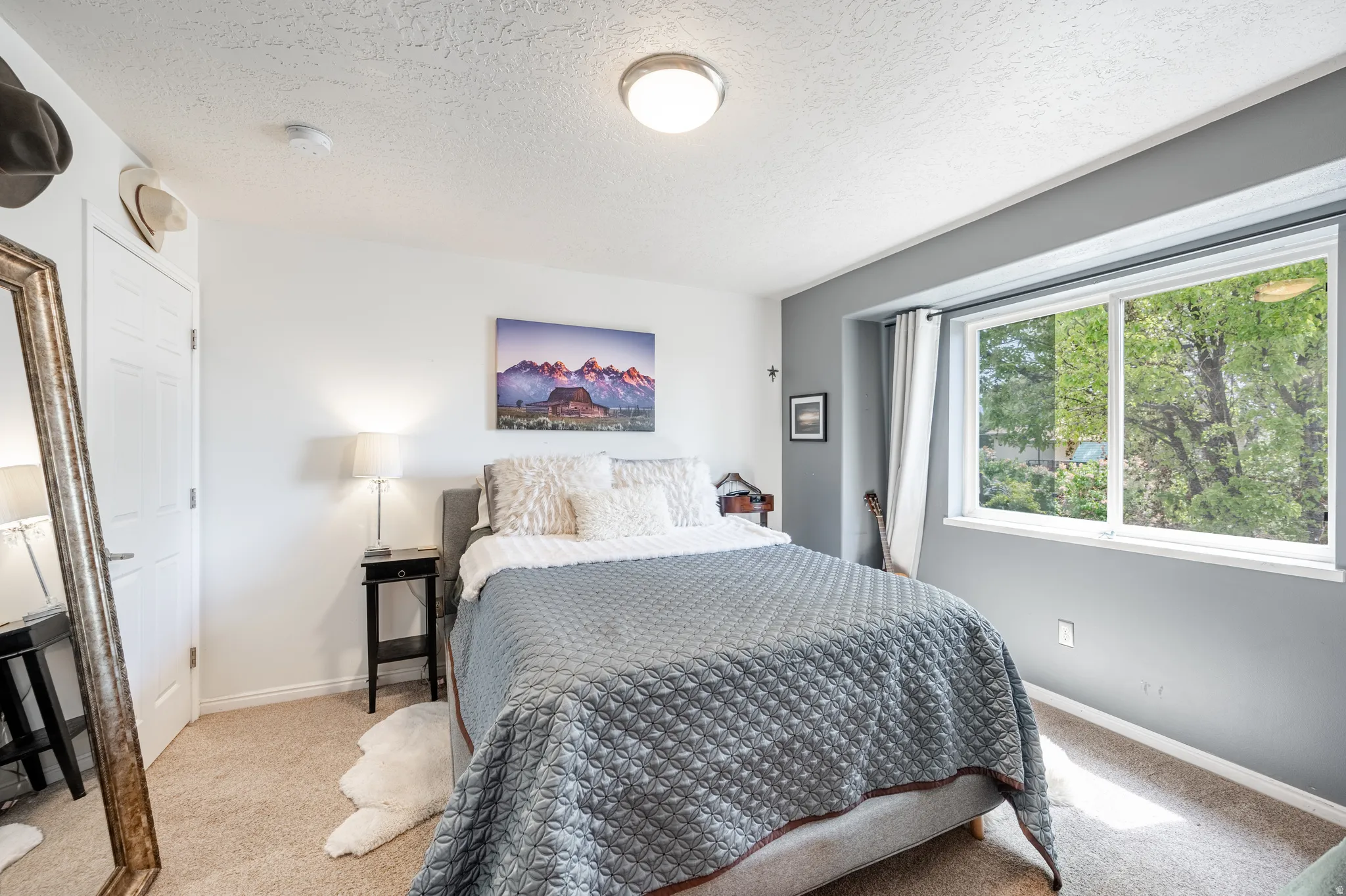 Carpeted bedroom featuring a textured ceiling and baseboards