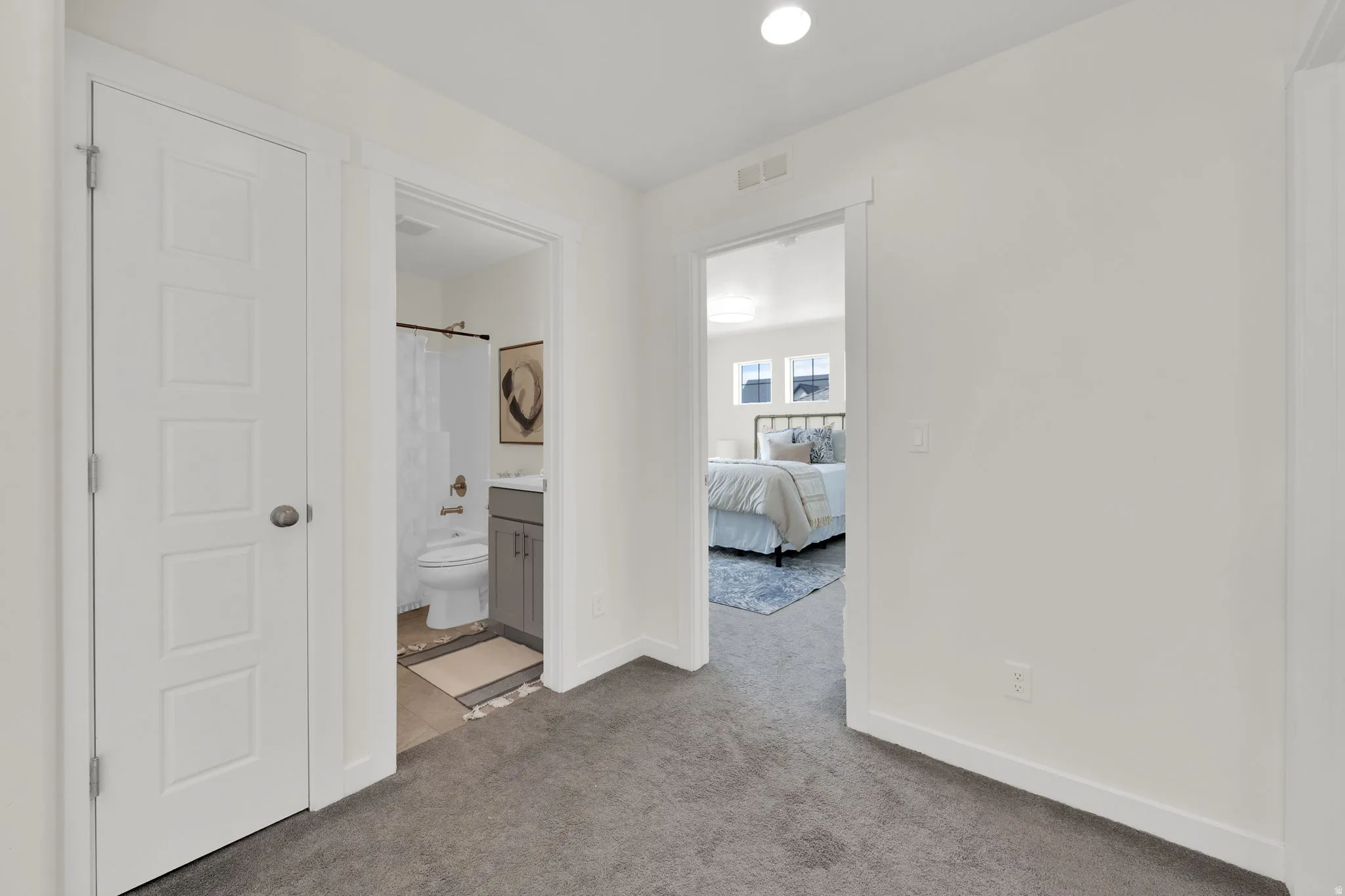 Corridor with light carpet and recessed lighting