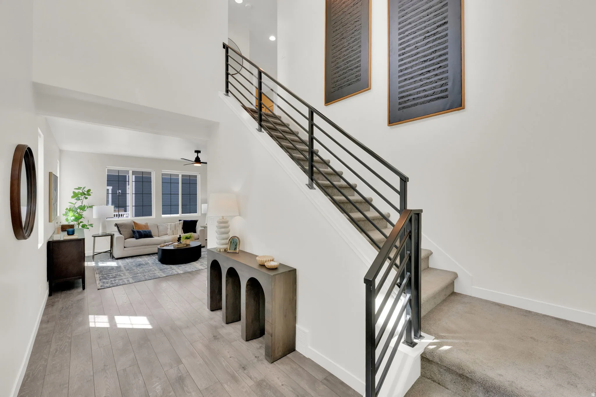 Entry hall and stairs featuring a high ceiling, a ceiling fan, and wood-type flooring