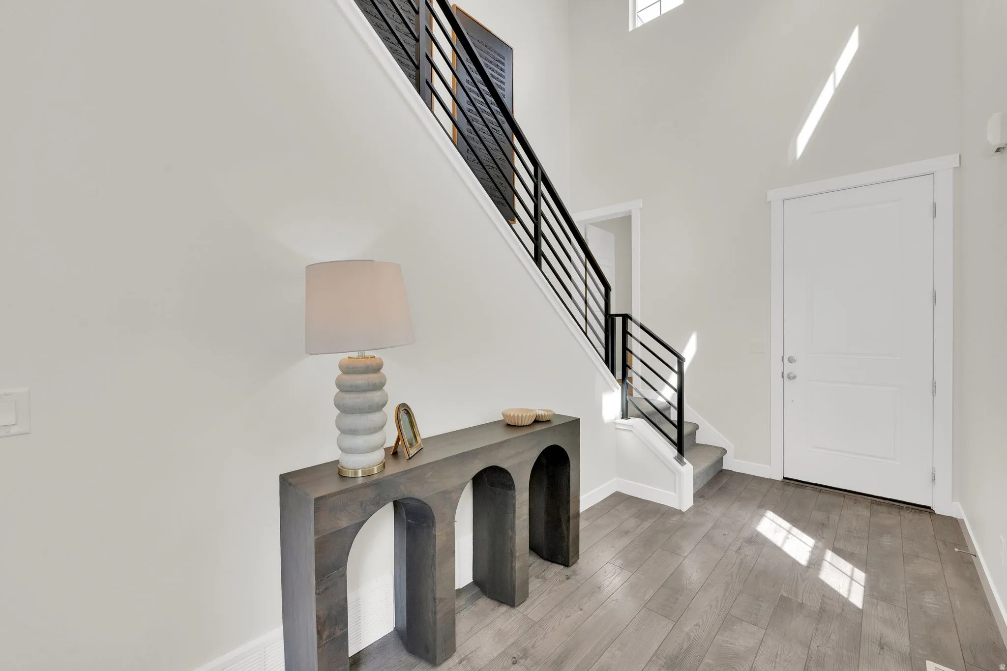 Foyer entrance featuring light wood-style floors and a high ceiling