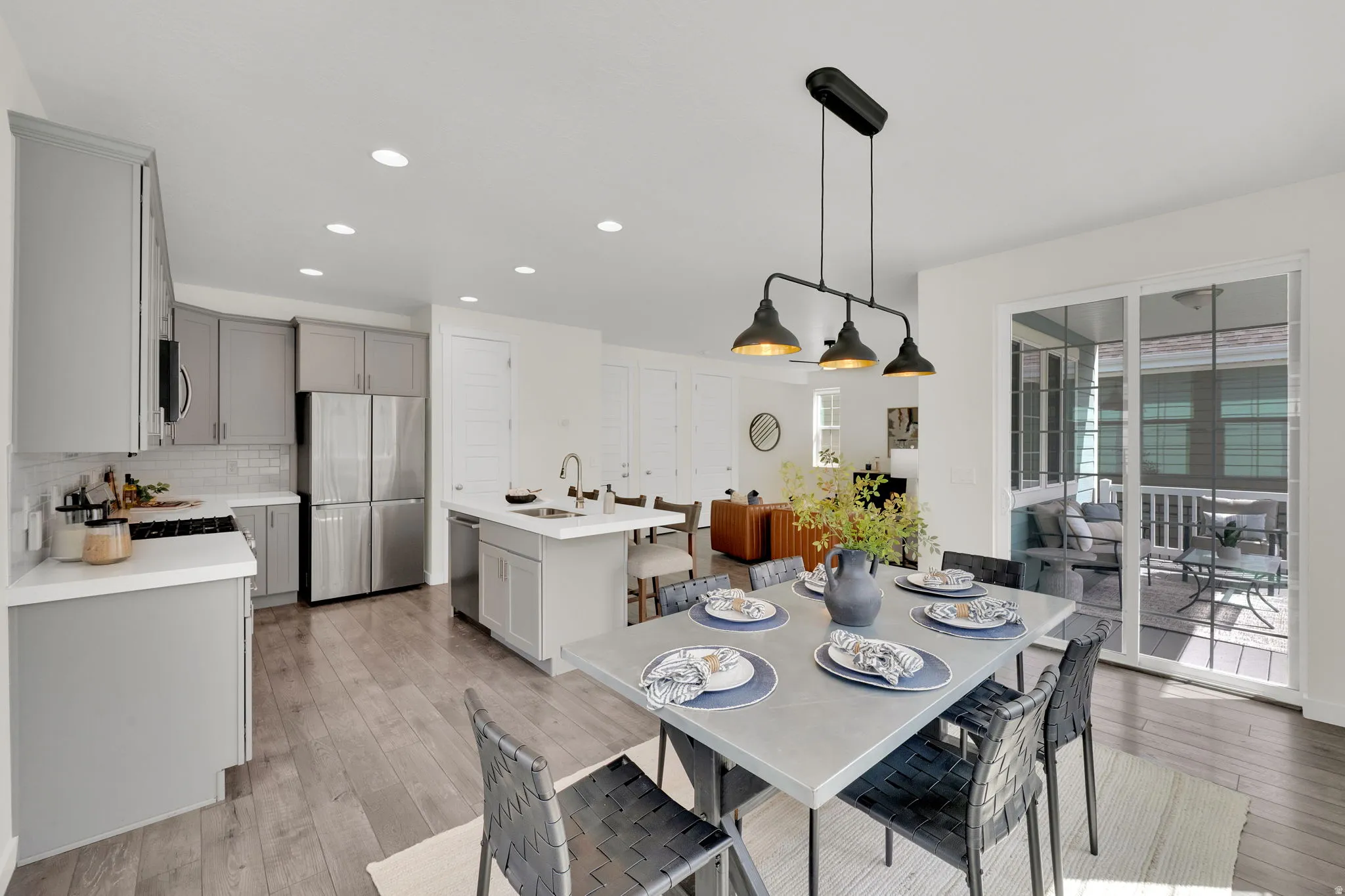 Dining space and kitchen featuring recessed lighting and light wood finished floors with access to covered deck and backyard