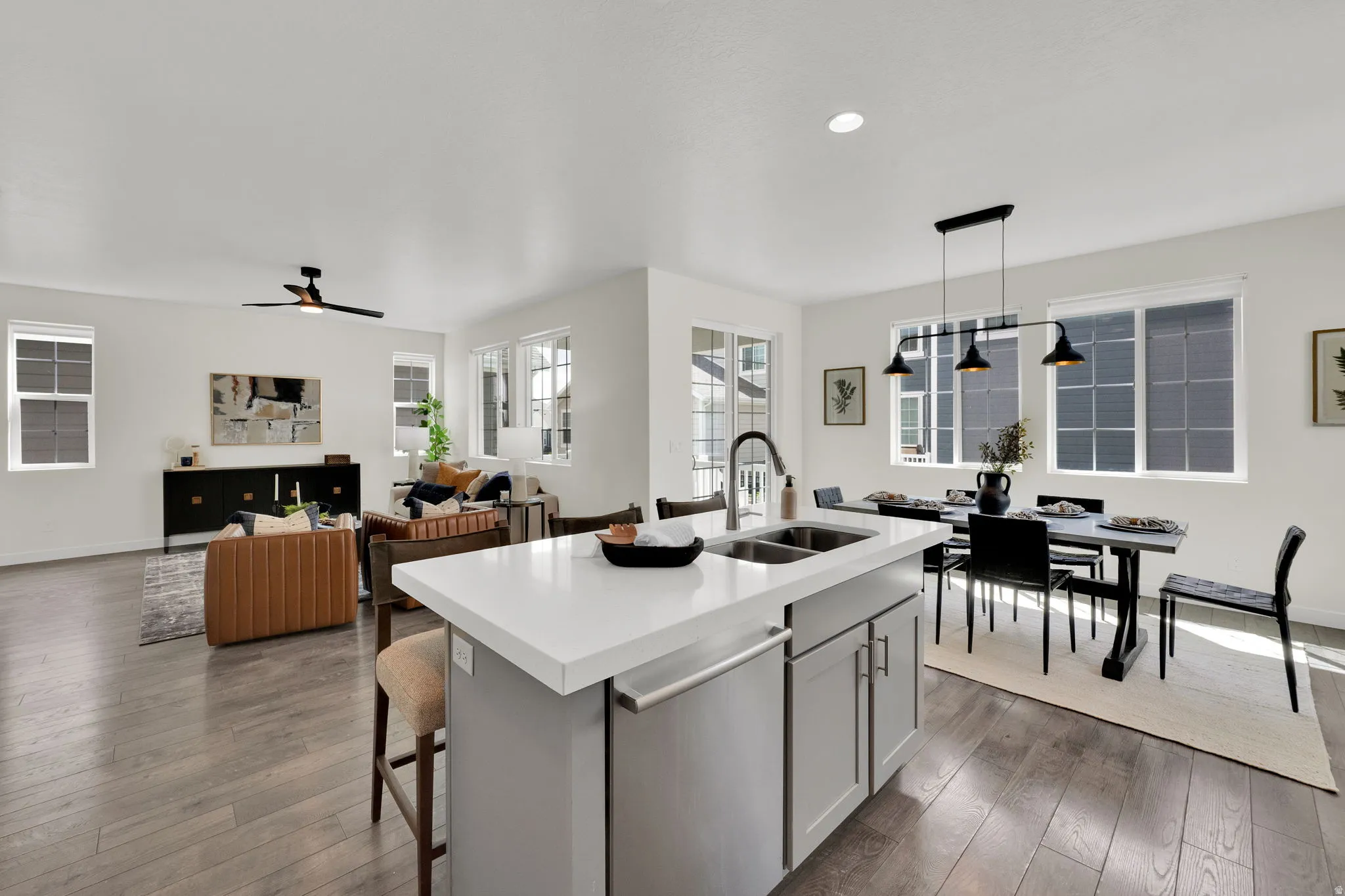 Kitchen featuring a kitchen island with sink, stainless steel dishwasher, a breakfast bar, hanging light fixtures, and open floor plan