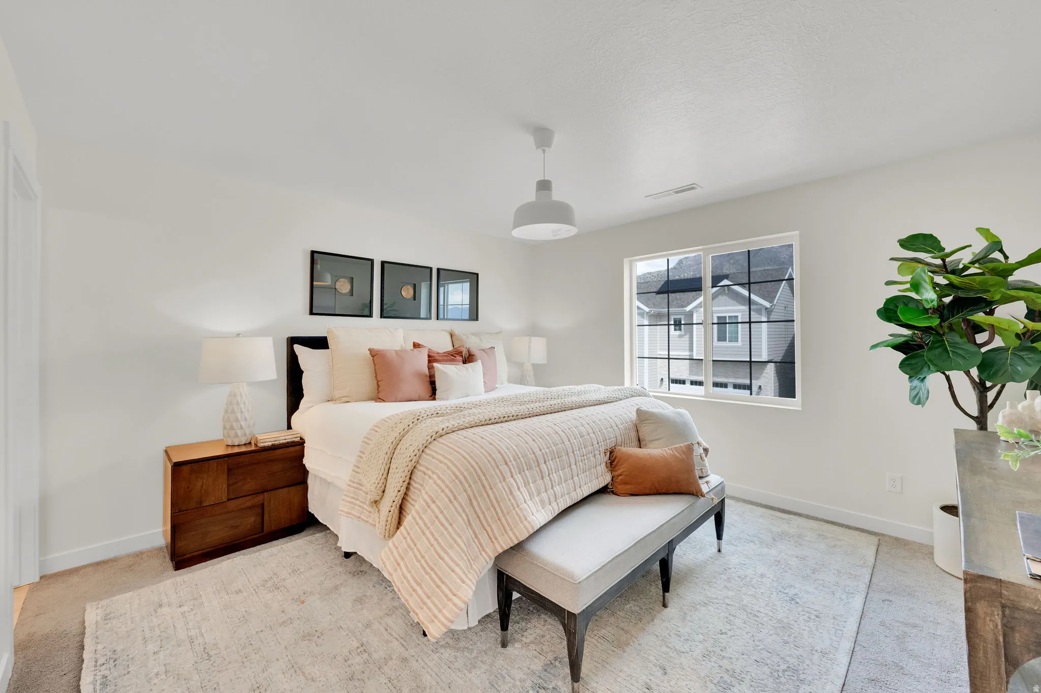 Primary Bedroom featuring baseboards and light carpet with window views of mountain.