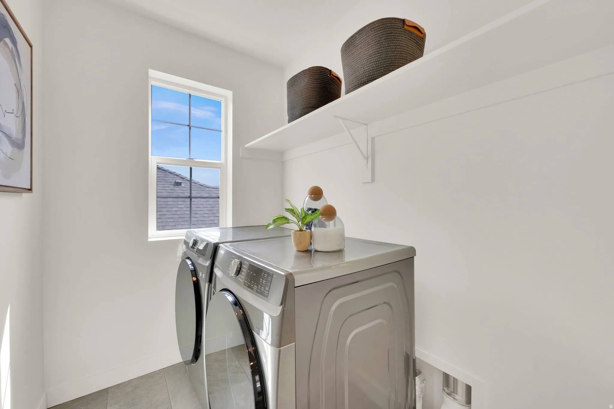 Laundry area with separate washer and dryer and baseboards