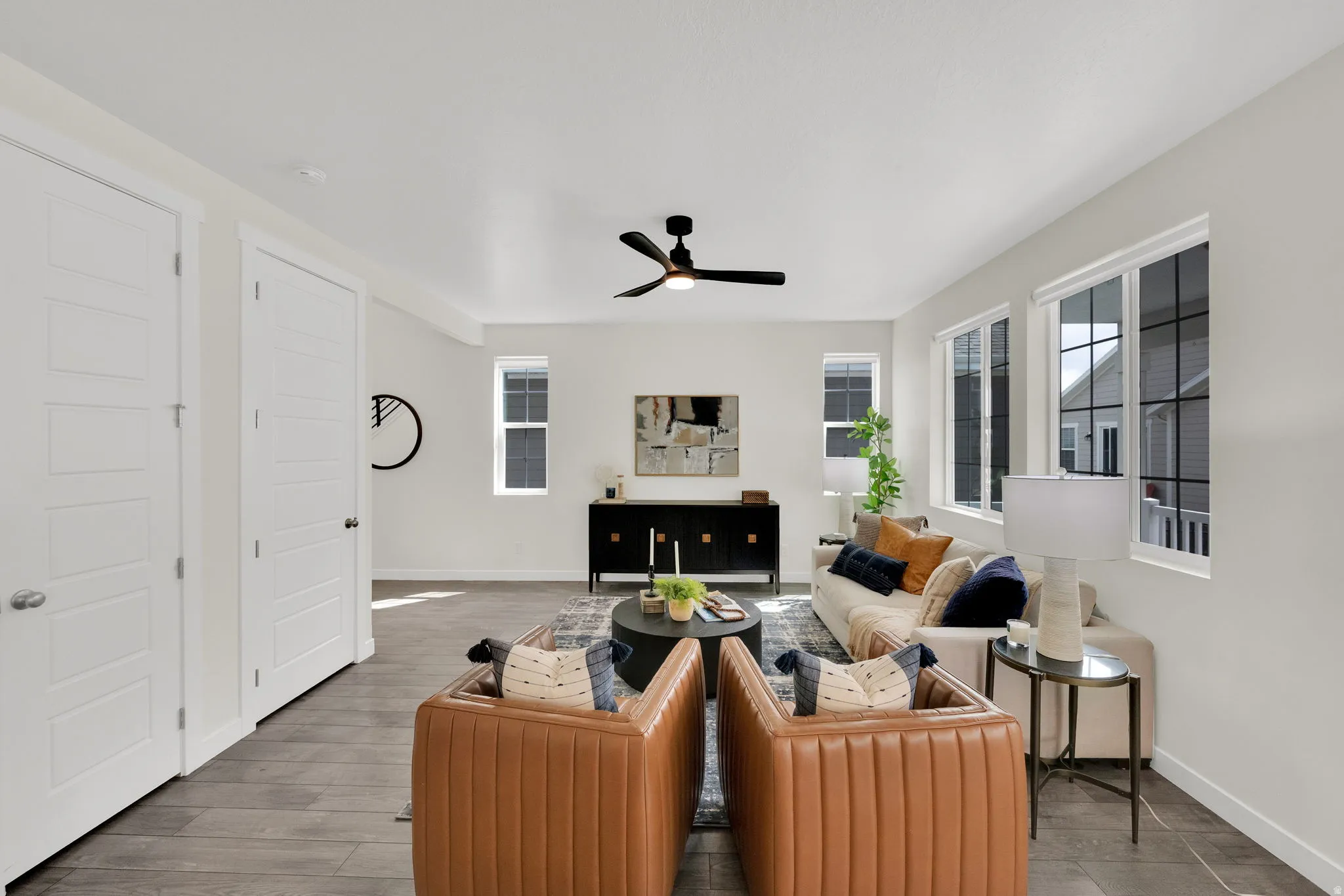 Living area with a ceiling fan, a fireplace, and wood finished floors