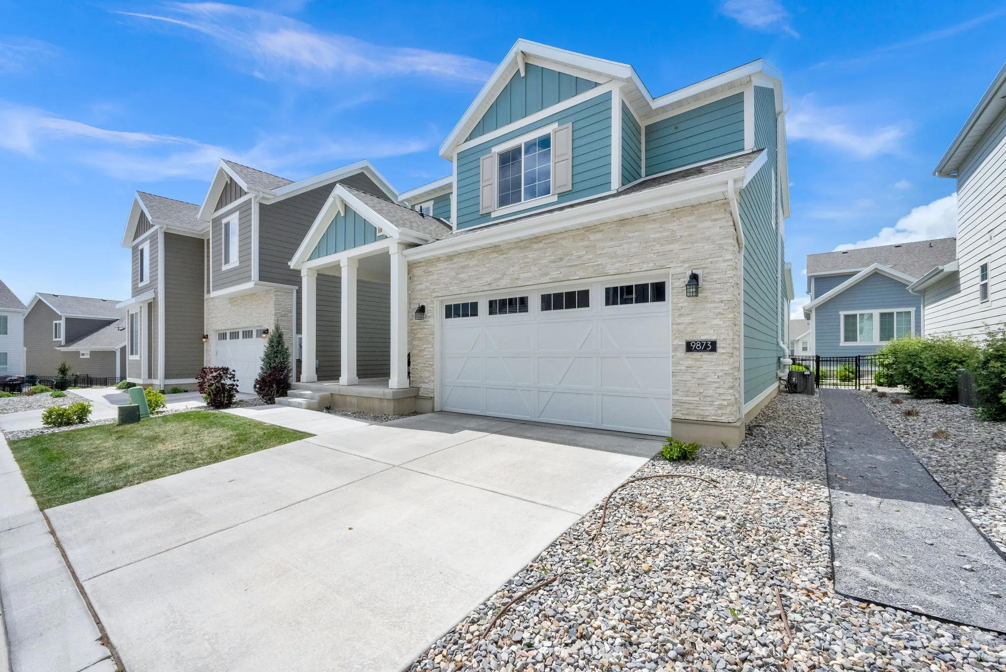 Craftsman inspired home with board and batten siding, an attached garage, concrete driveway, and stone siding