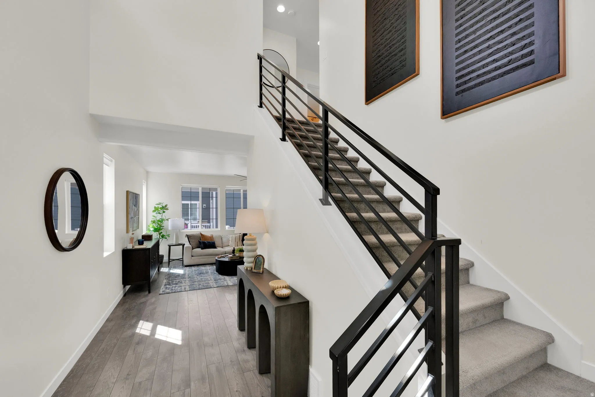 Stairs with a high ceiling and wood finished floors