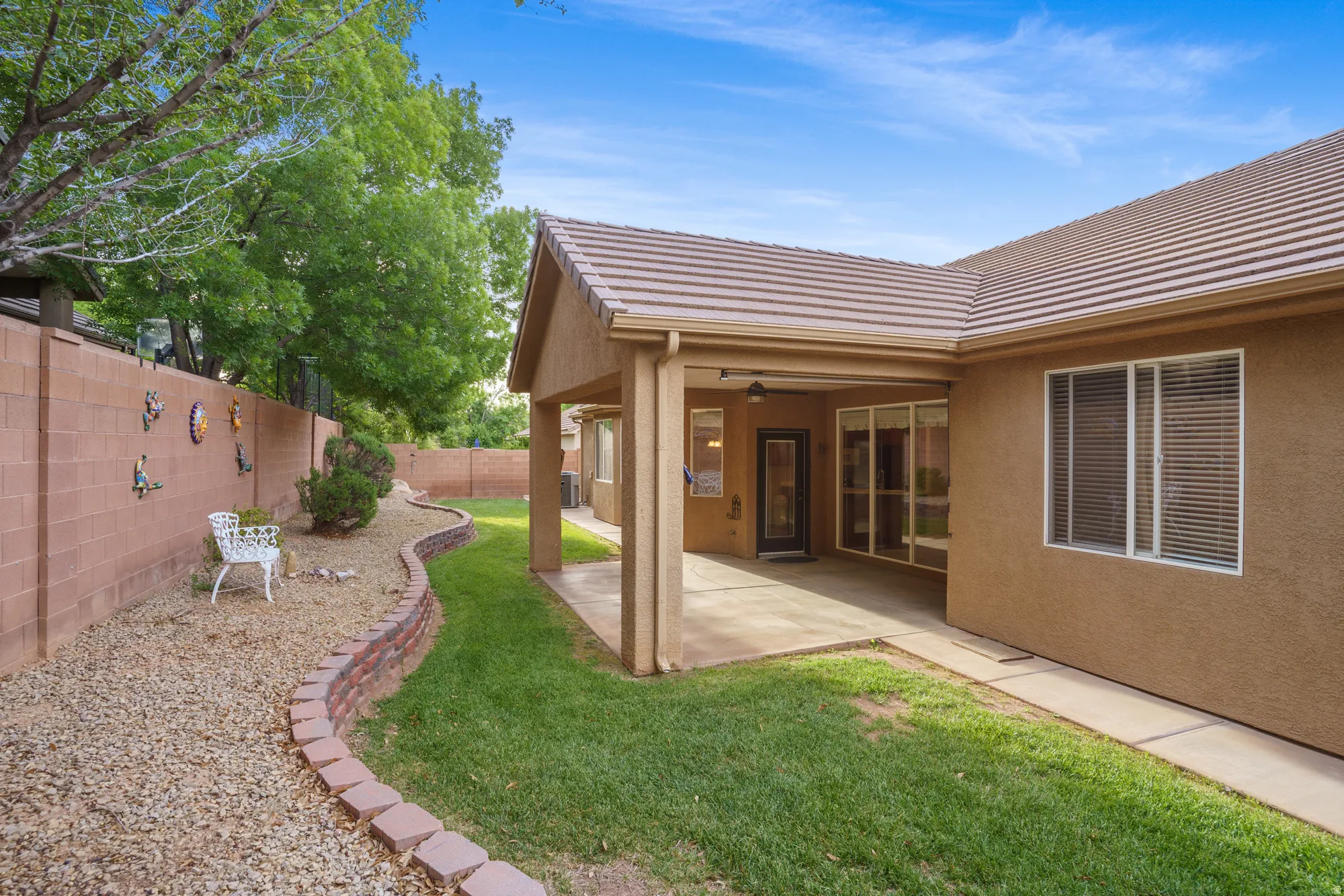 Fenced backyard featuring a patio area and a ceiling fan