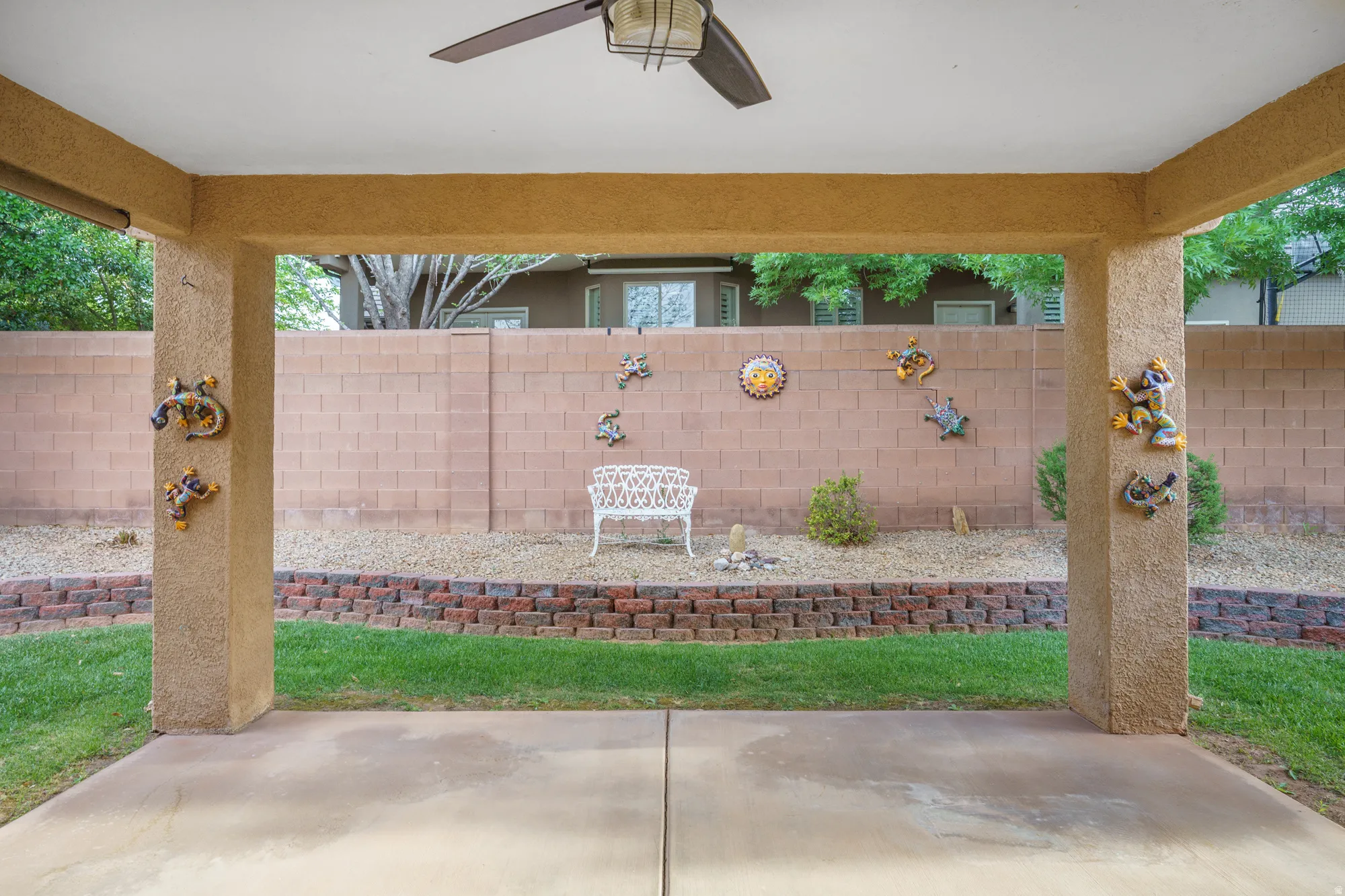 Fenced backyard featuring a ceiling fan and a patio