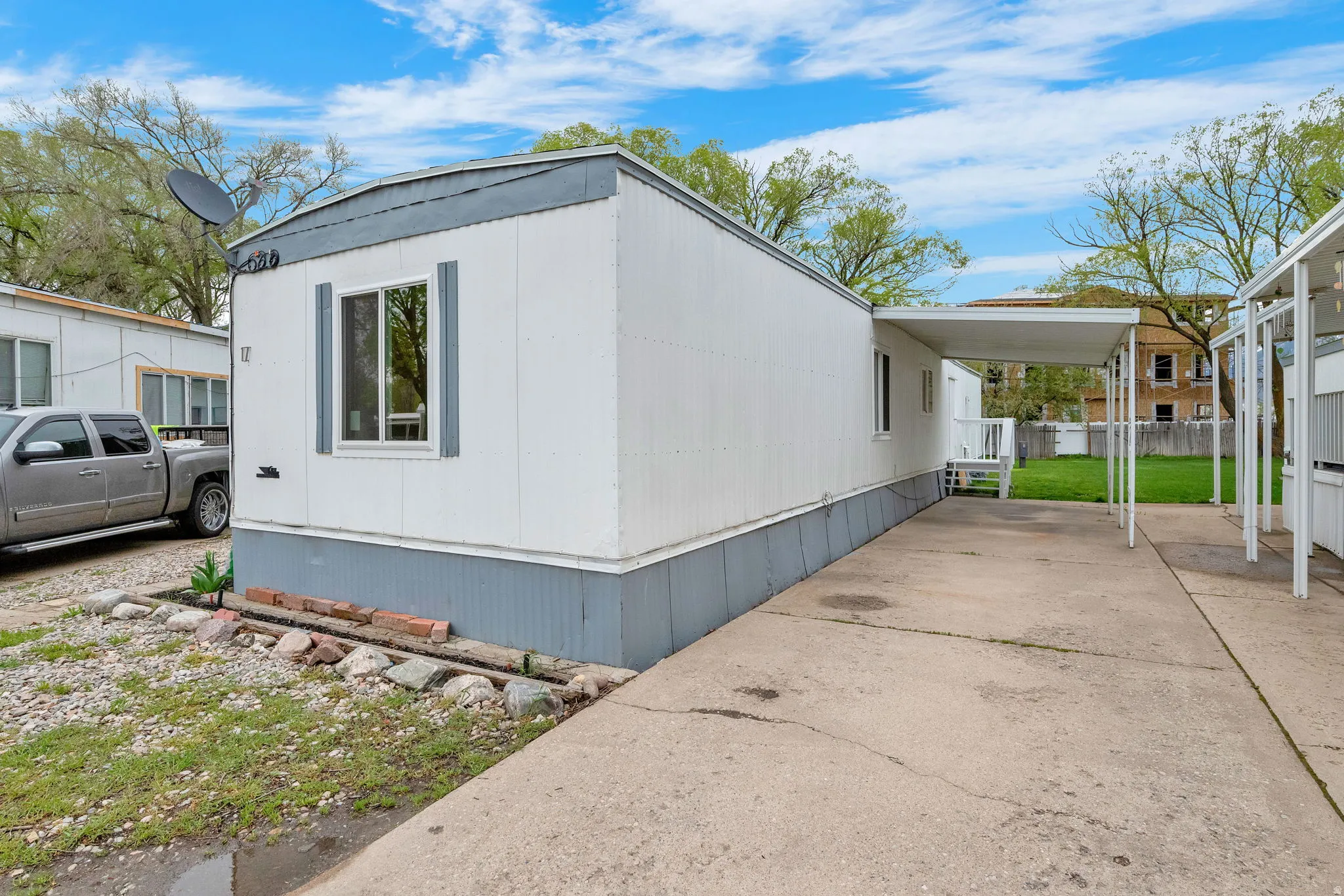 View of property exterior featuring an attached carport and driveway