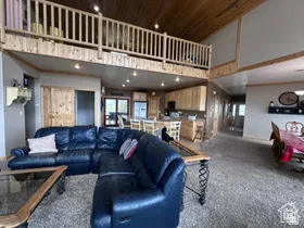 Carpeted living room with a high wood ceiling and recessed lighting