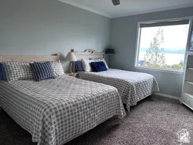 Carpeted bedroom featuring crown molding and ceiling fan