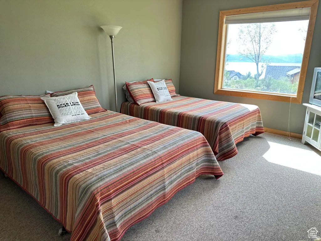 Bedroom featuring light carpet and baseboards