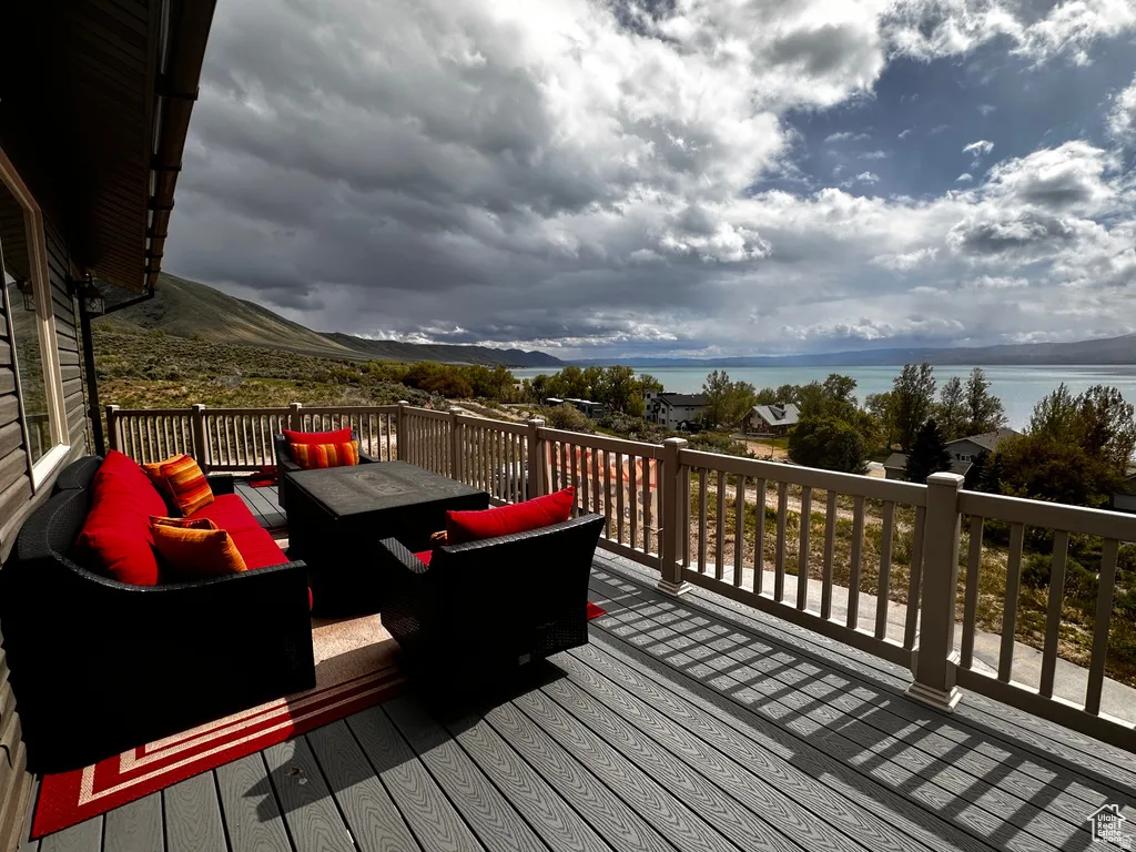 Wooden terrace with an outdoor living space and a water view