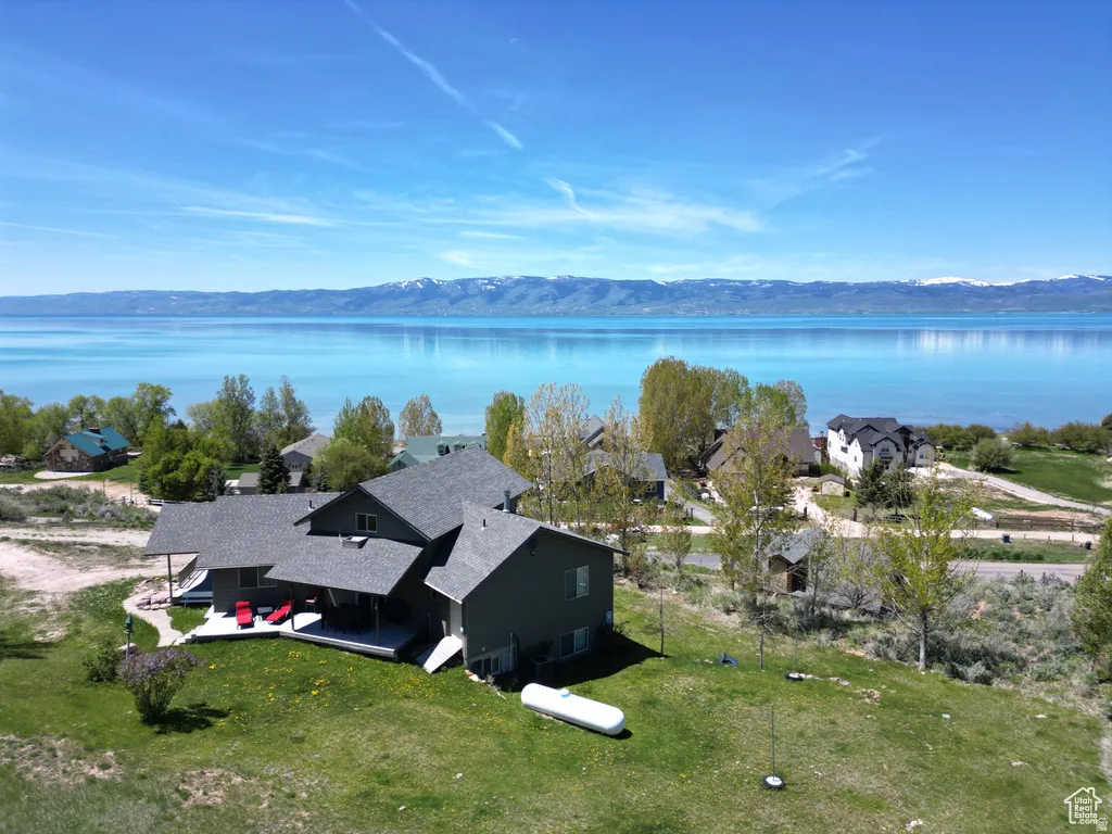 View of subject property with a water and mountain view