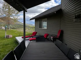 Wooden terrace featuring a lawn, an outdoor hangout area, and a mountain view