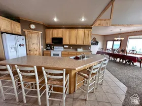 Kitchen with white appliances, a kitchen bar, light countertops, light tile patterned floors, and crown molding