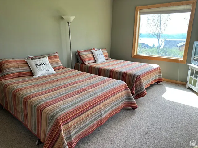 Bedroom featuring light carpet and baseboards