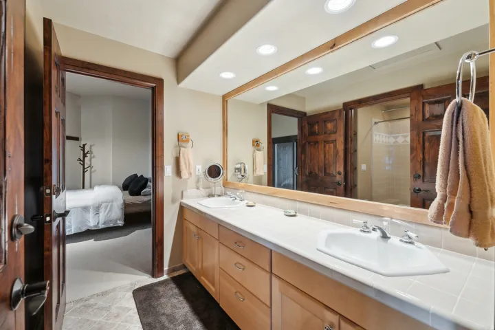 Ensuite bathroom with a stall shower, recessed lighting, and double vanity
