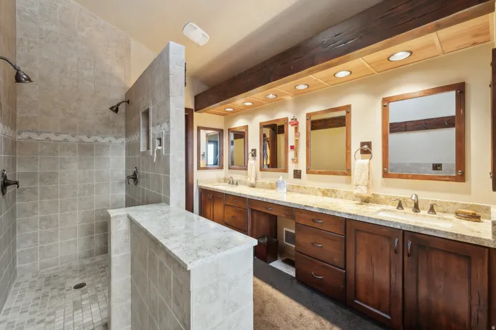 Primary suite bathroom featuring double vanity, walk in shower, and recessed lighting