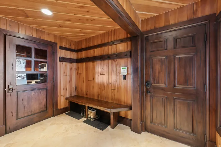 Foyer area with door to garage, showing solid cherry wood custom benches, paneling, and shelving.