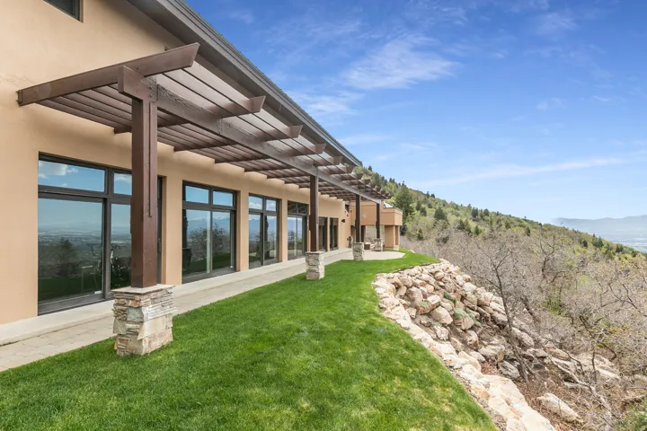 Exterior featuring an extended pergola with wood beams and stone-clad columns
