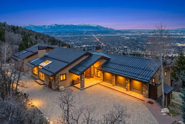 East side view of house with Stone and Stucco siding, mtn views, heated driveway, & maintenance free copper roof.