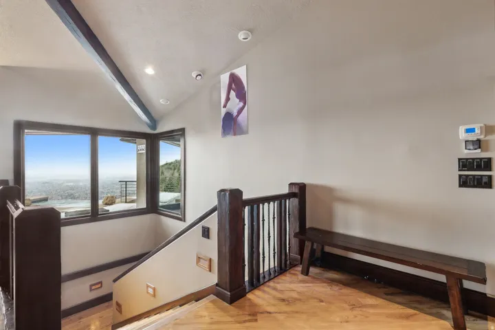 Stairs featuring hardwood finished floors, beamed ceiling, and valley view