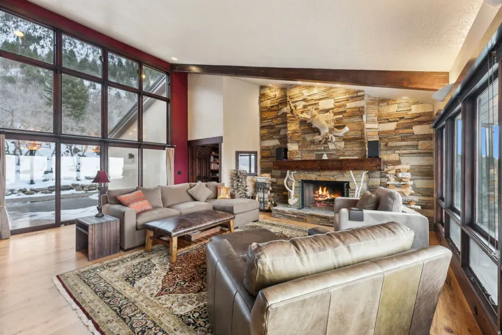 Living room featuring vaulted ceiling, a fireplace, and wood finished floors