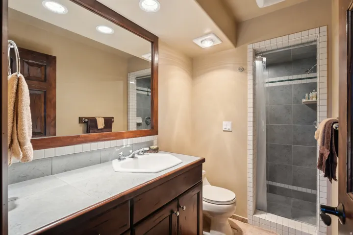 Bathroom featuring a shower stall, vanity, and decorative backsplash