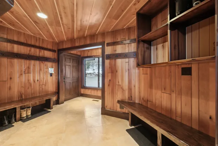 Mud room again with tile flooring, and garage entrance door in background.