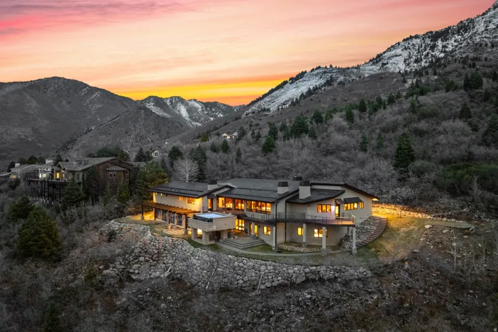 Back of house at dusk featuring a chimney and a deck with mountain view