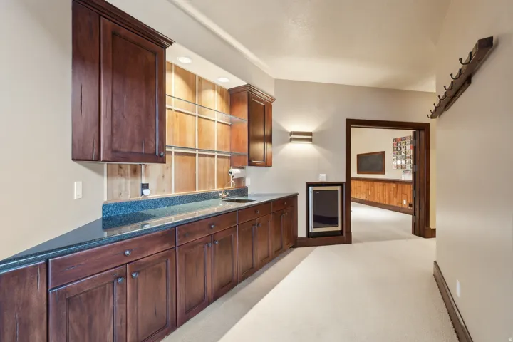 Wet bar down featuring wine frig between pool room and billiards lounge.