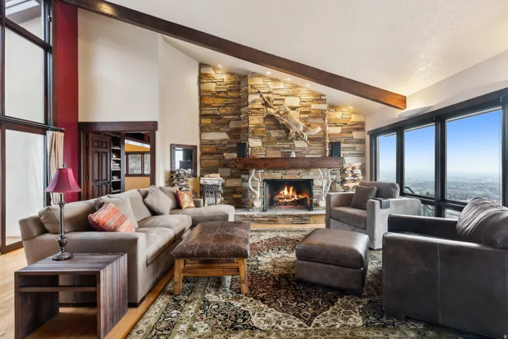Living room featuring lofted ceiling, plenty of natural light, a fireplace, and wood finished floors