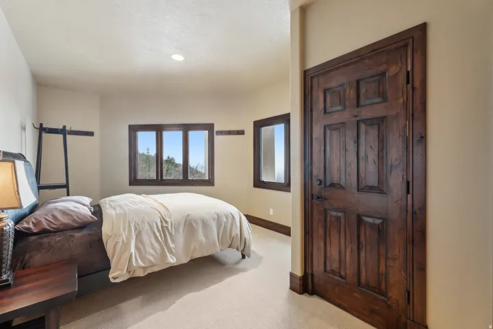 Bedroom with baseboards and light colored carpet