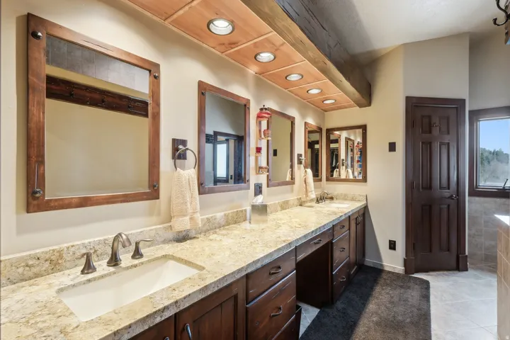 Primary suite bathroom featuring double vanity, recessed lighting, and light tile patterned floors