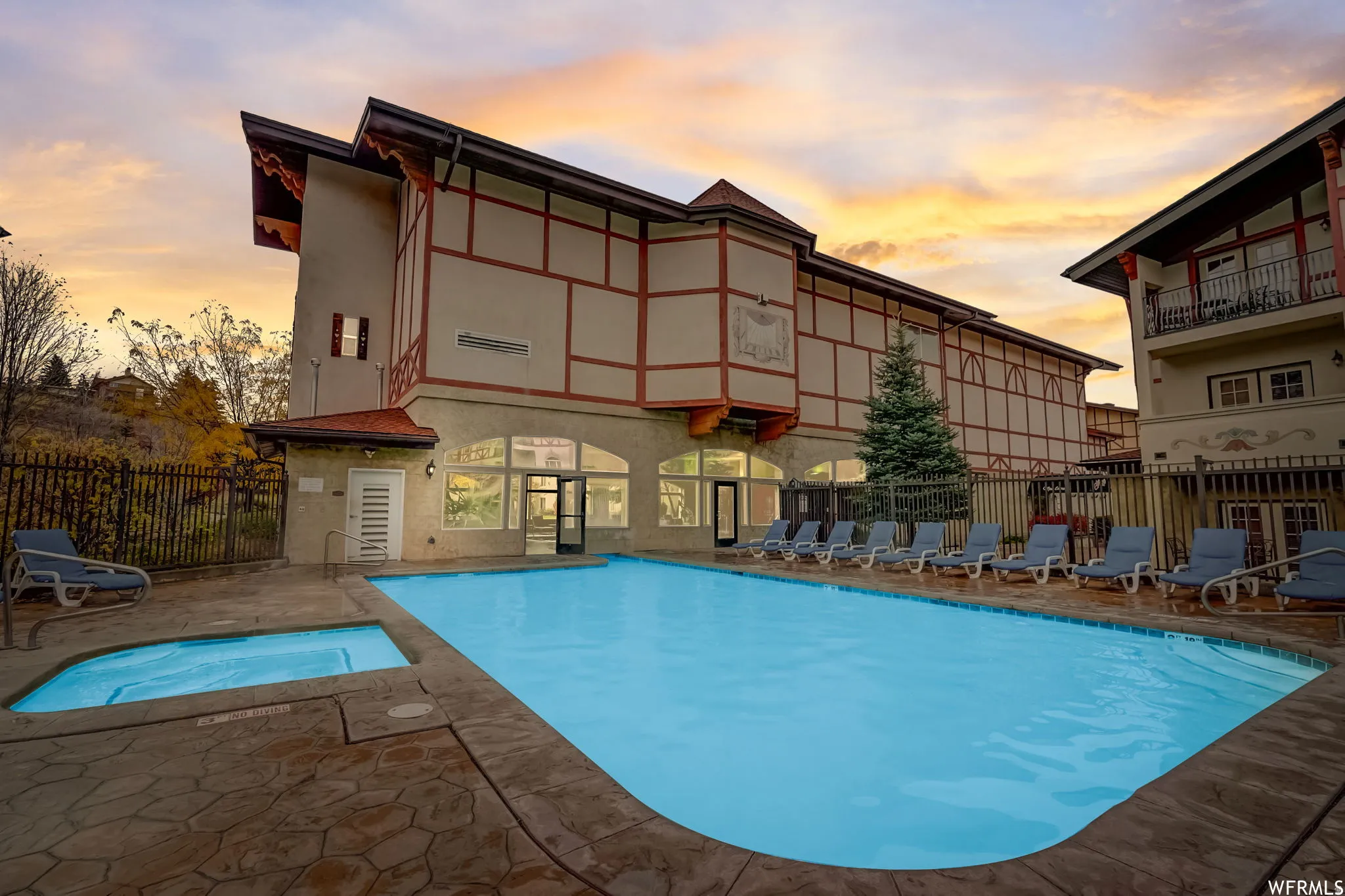 Community pool with a patio area and a community hot tub