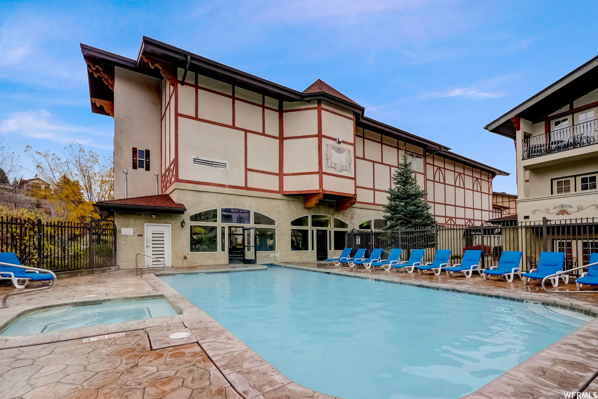 Community pool with a patio area and a community hot tub