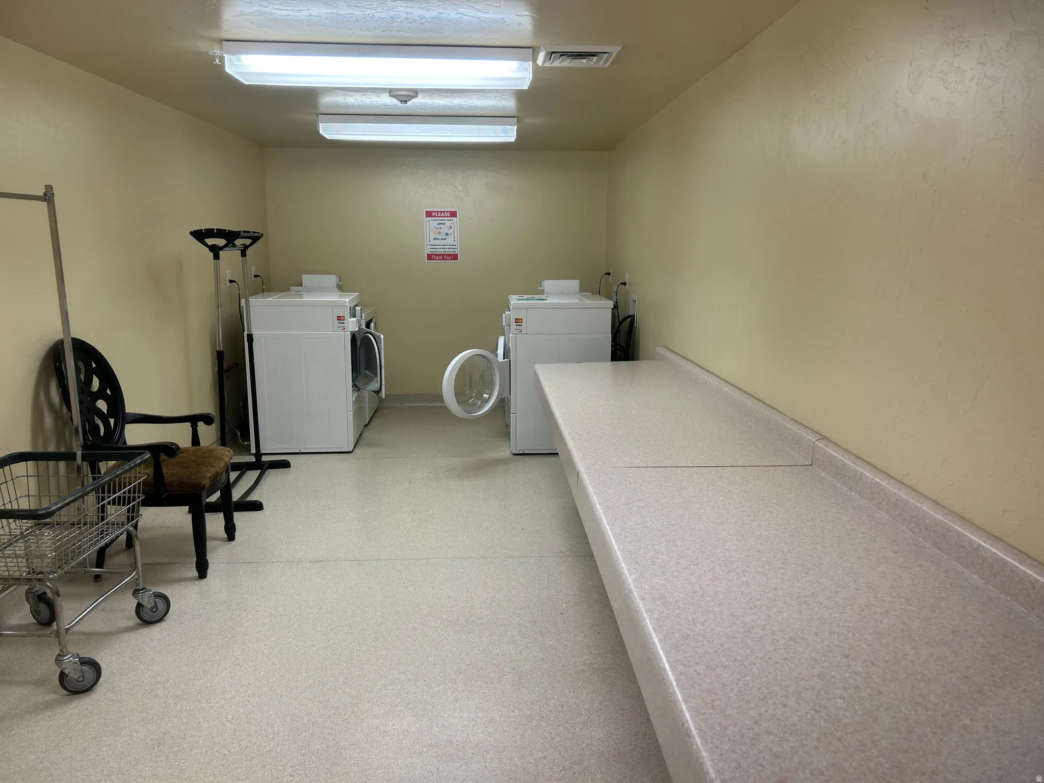 Communal laundry room featuring washing machine and clothes dryer