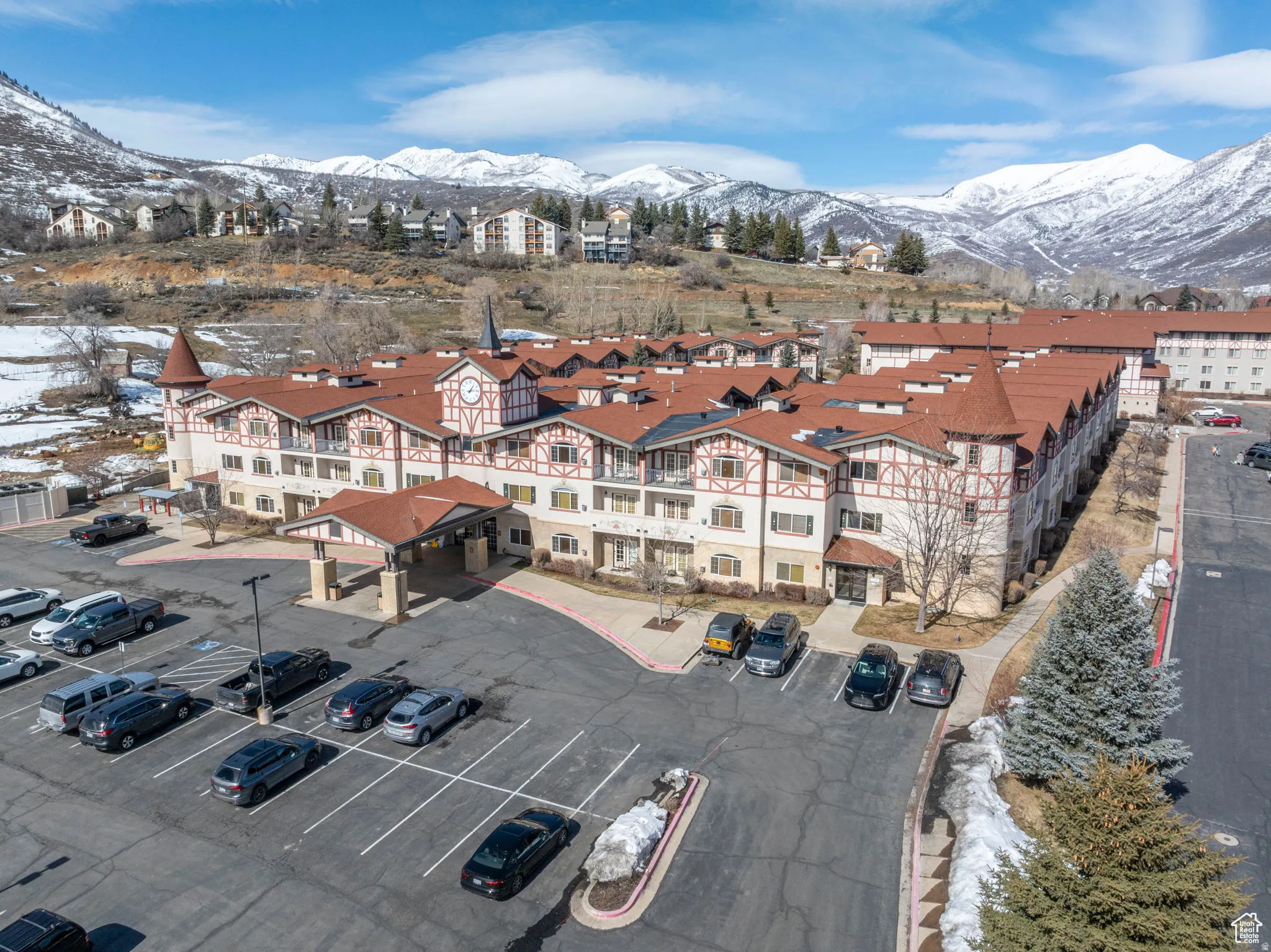 Snowy aerial view with a mountain view and a view of the complex