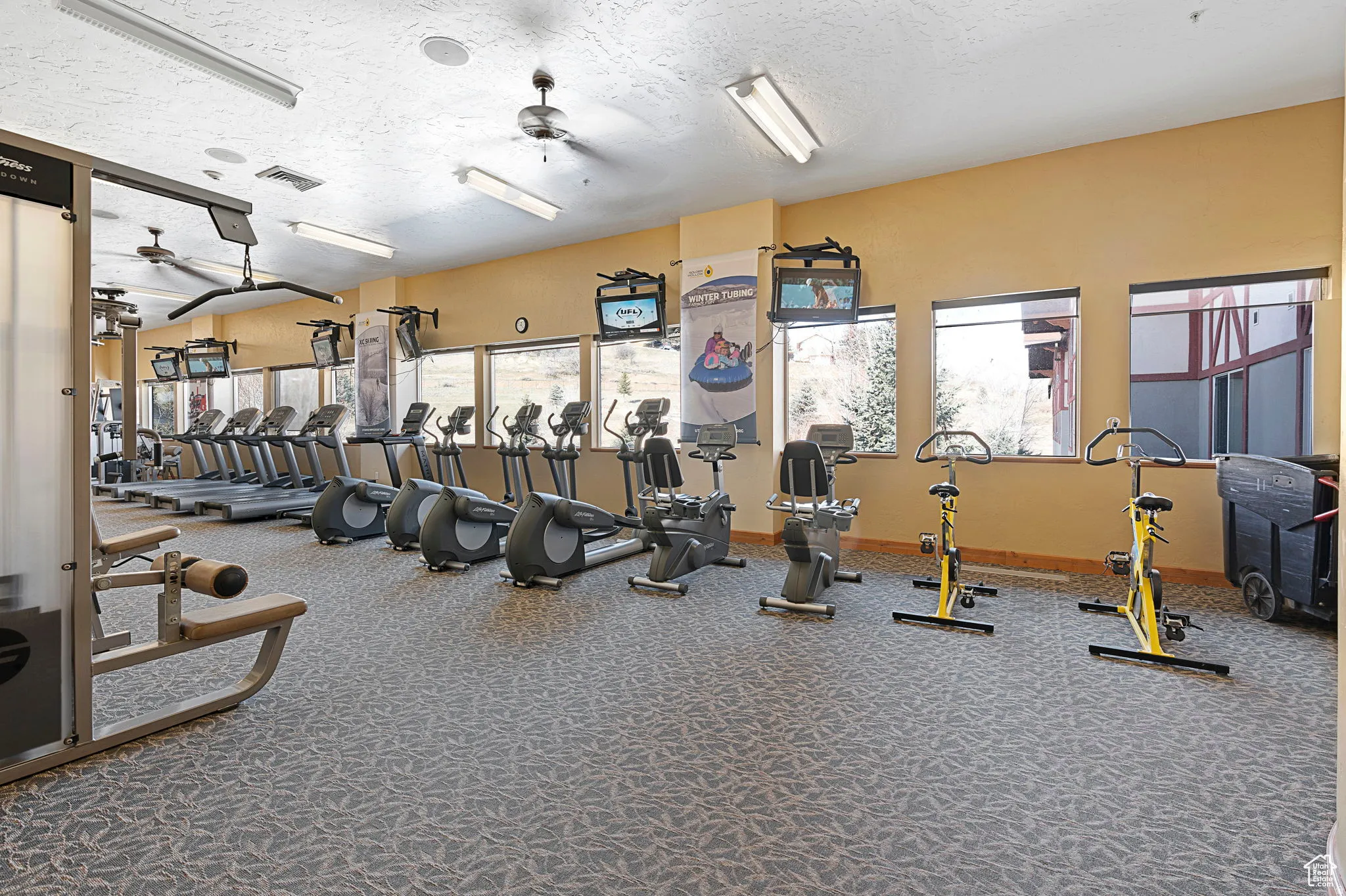 Gym featuring a textured ceiling and ceiling fan