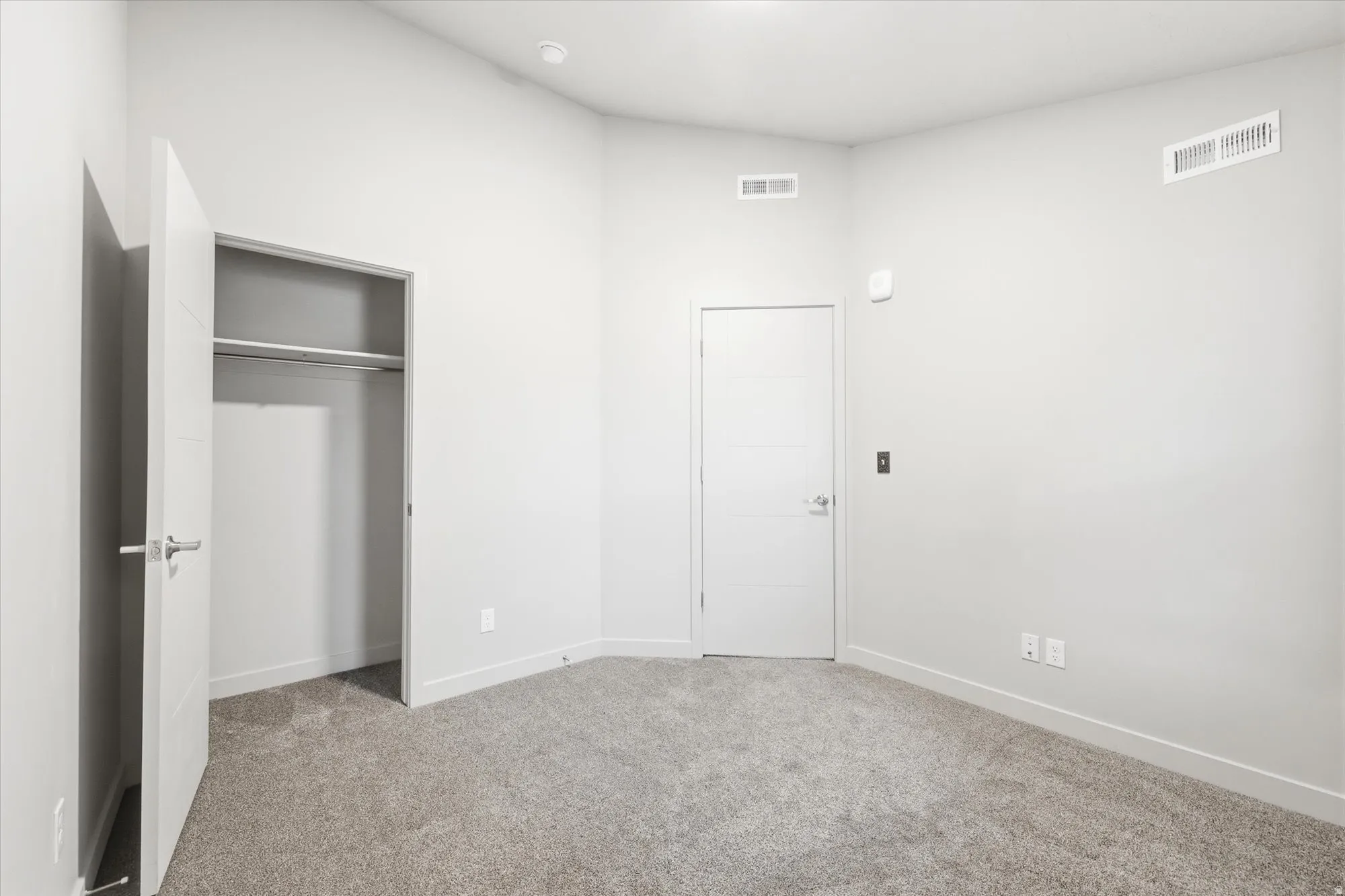 Unfurnished bedroom featuring light colored carpet and a closet