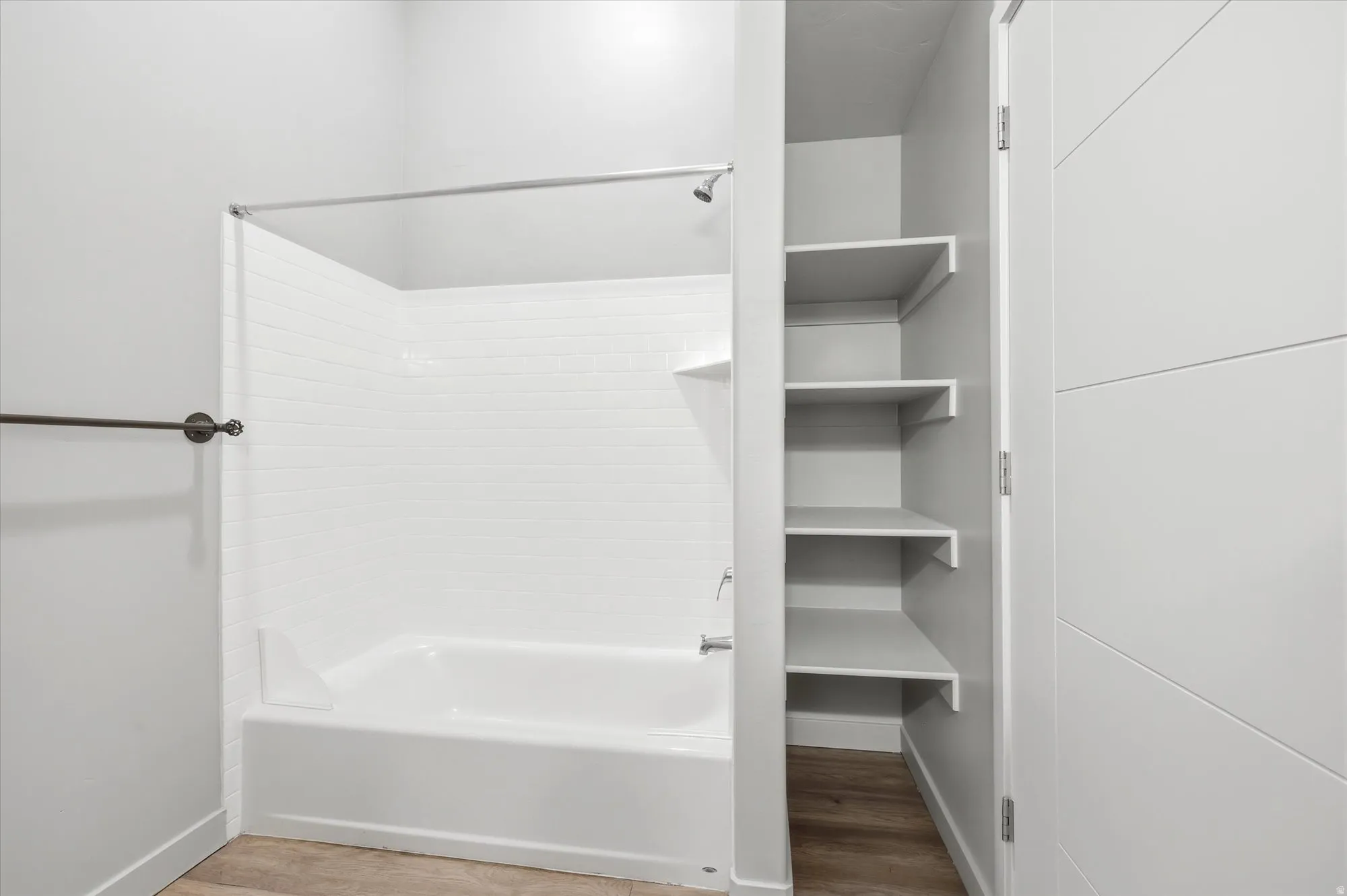 Bathroom with light wood finished floors and shower / washtub combination