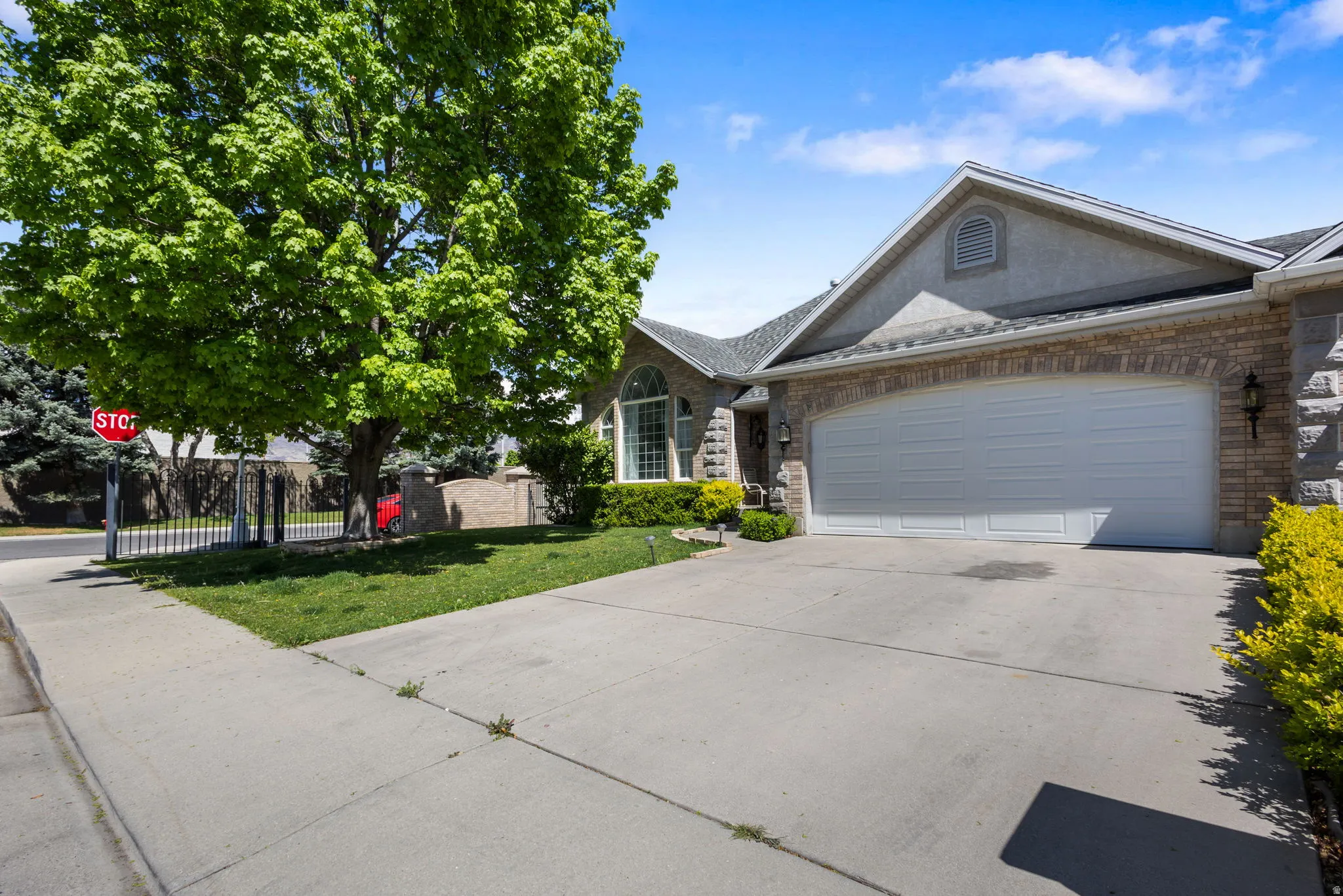 Ranch-style house with an attached garage, concrete driveway, brick siding, and a shingled roof